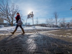Photo of a student walking across the snowy campus of 青青草app State University