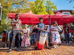 the Cali School鈥檚 Afro-Caribbean Ensemble on campus with microphone and drum